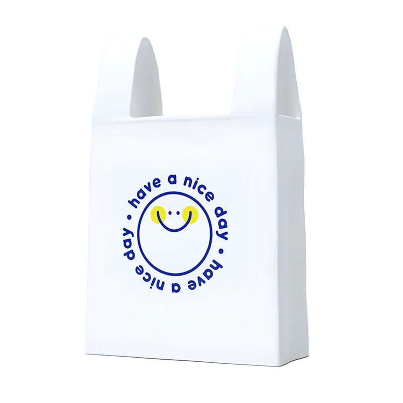 A white ceramic bag with integrated handles, featuring a blue circular smiley face graphic and the text 'have a nice day' printed on the front.