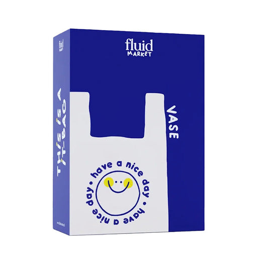 A blue and white bag vase packaging box for 'fluid MARKET' branded bags, featuring a white cutout shape of a bag with a smiley face and the text 'have a nice day'.