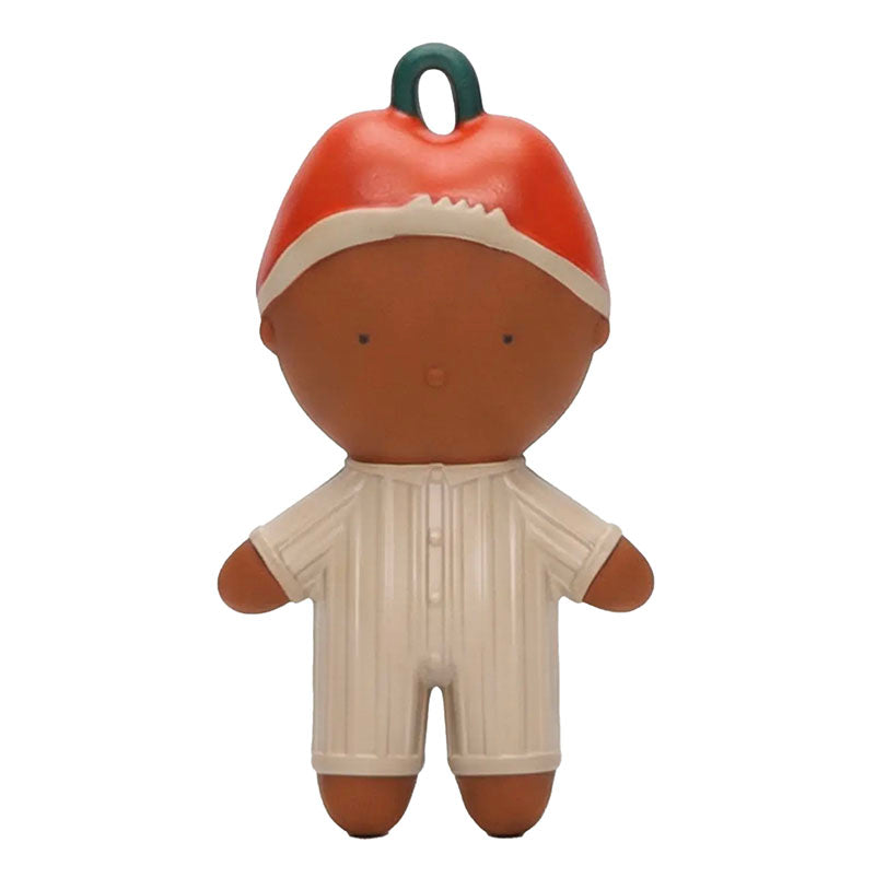 A stylized plastic toy figure with a brown face and limbs, wearing a red and white hat and a cream-colored striped romper, featuring a dark green hanging loop on top.