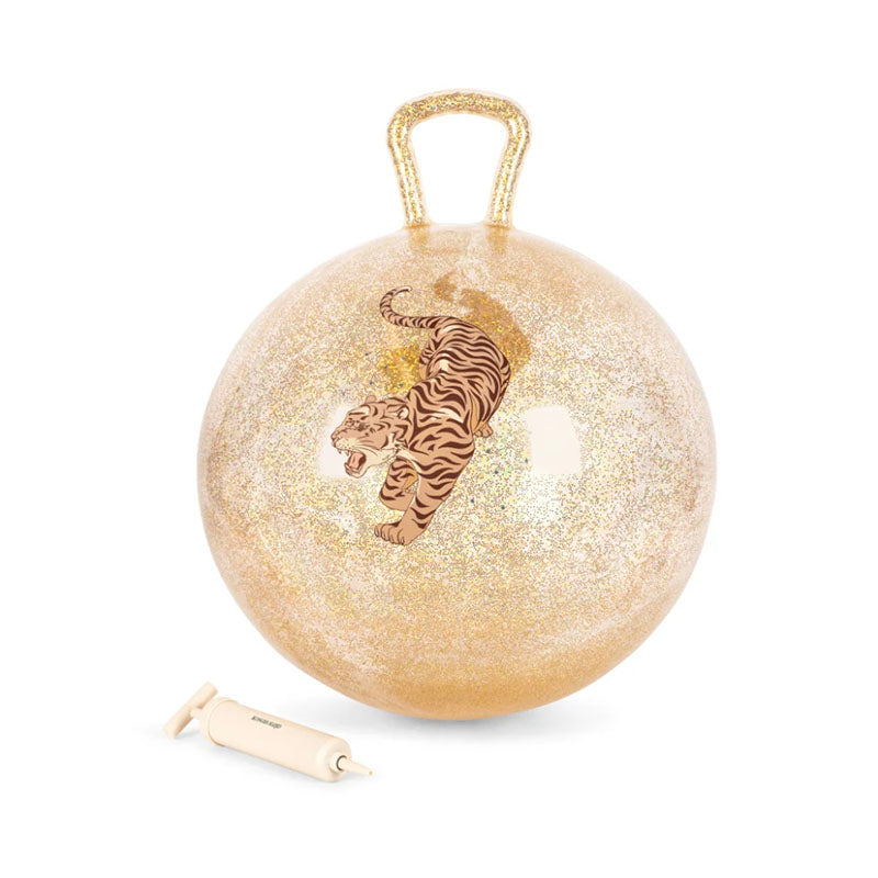 A round, gold glittery ball-shaped product with a handle on top, featuring an illustration of a tiger on the front. A small beige pump is placed below it 