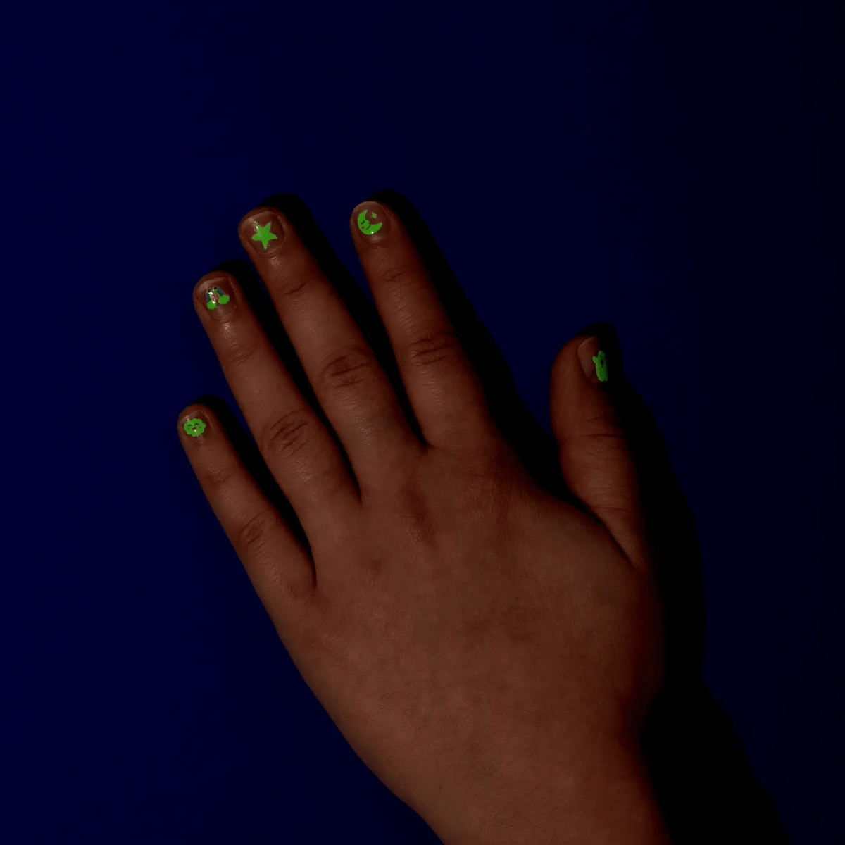 Hand with green, glow in the dark nail stickers 