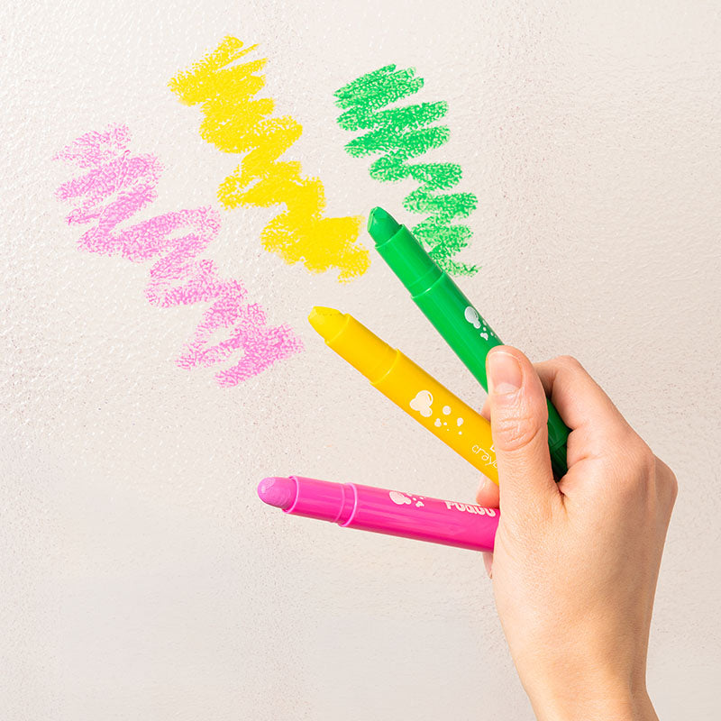hand holding 3 bath crayons, 1 pink, 1 yellow and 1 green with example drawings of those crayon colours.