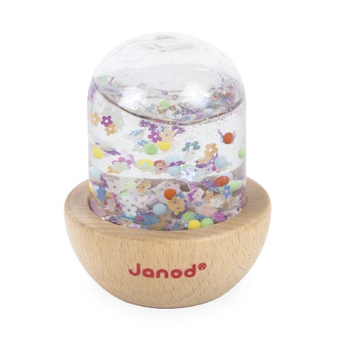 Wooden toy with a clear top and colorful confetti in water, featuring the brand 'Janod'.